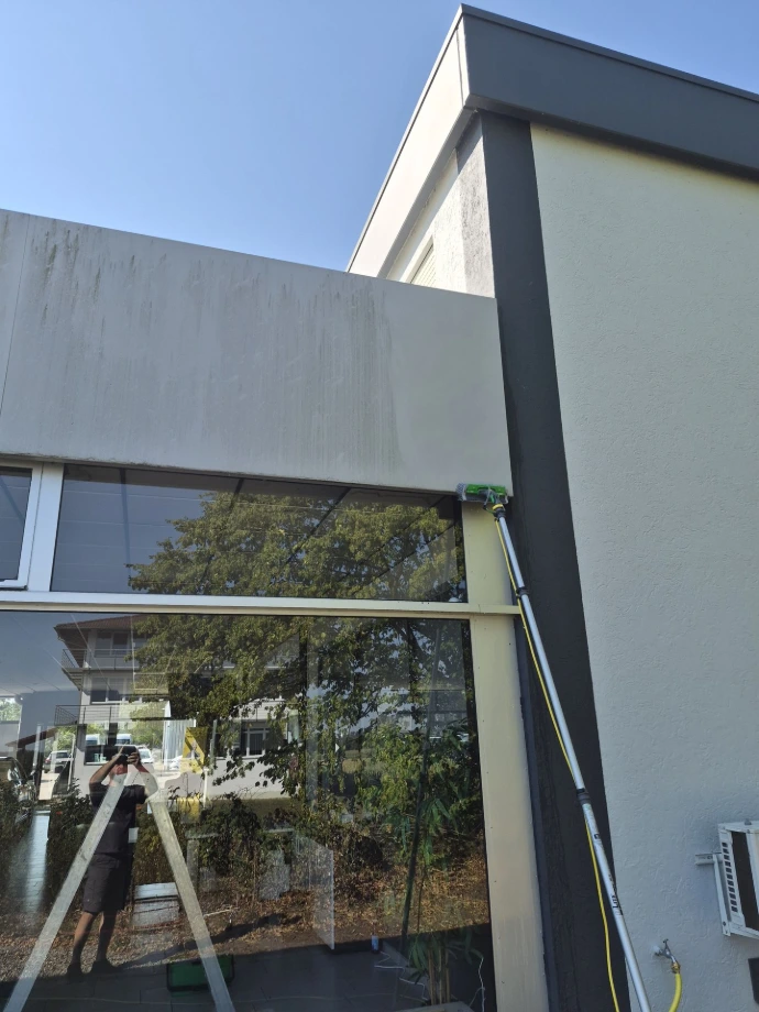 Reinigung der Glasflächen und Fassadenverkleidung mit Reinwasser und Teleskopstange am Autohaus Pütz in Bad Wörishofen